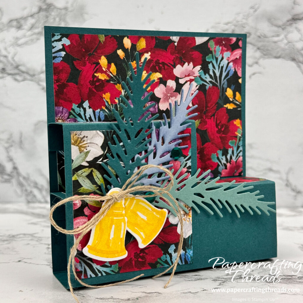 Fun Fold Fold Flat Card in Pretty Peacock with two tiered platforms, floral patterns, bells, pine sprigs and a linen thread bow