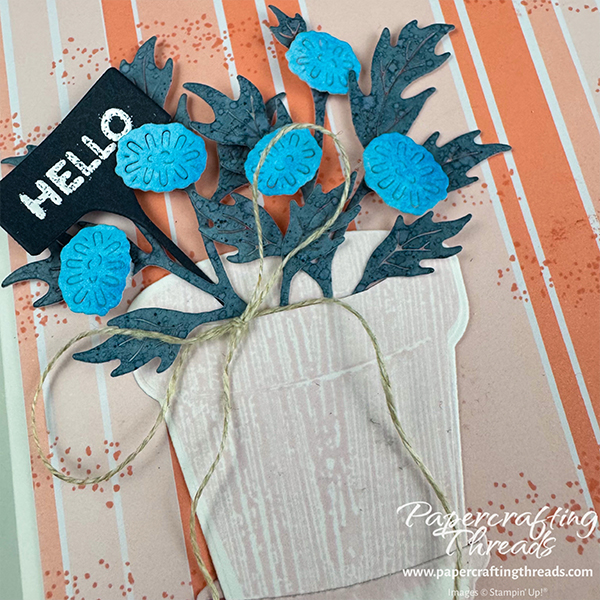 Complementary Crisp Cantaloupe color scheme card. Card features Crisp Closeup of Cantaloupe vertical stripes with stamped splotches. Flower pot with bright blue florals, darker leaves and a cheery 'Hello' plant pick