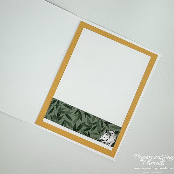 Step Up Your Cardmaking sample card inside with leafy patterned papers strip layered over white liner and backed with golden glow cardstock. A playful kitten is located in the lower right corner.