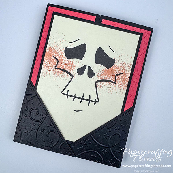 Pocket Gatefold Card has a black card base with Calypso Coral embossed panels. Two black embossed overlapping right triangles form a pocket to hold the skeleton face insert.