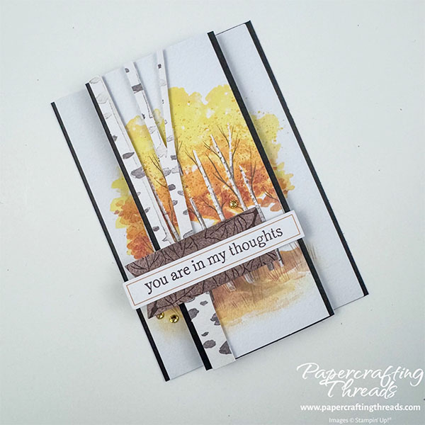 Triple Panel Standing Card Closed Front View. Two narrow panels flank a wider central panel with a scene of golden-leaved aspen trees. A speckled trunk overlays the grove. A brown wood-like label sets off the sentiment strip that reads 'you are in my thoughts'.